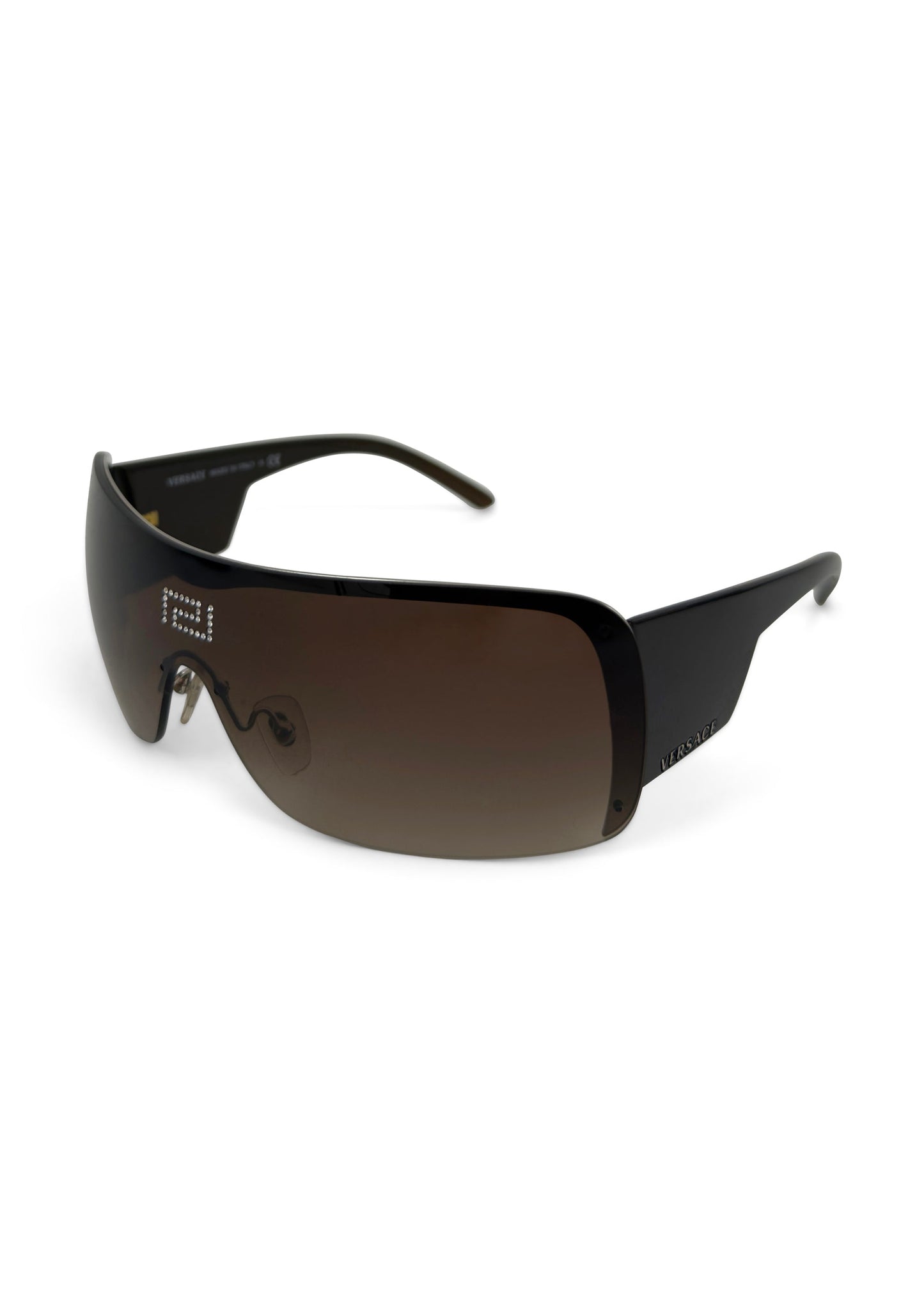 Brown frameless Versace shield sunglasses with rhinestone Greek Key emblem on temple.